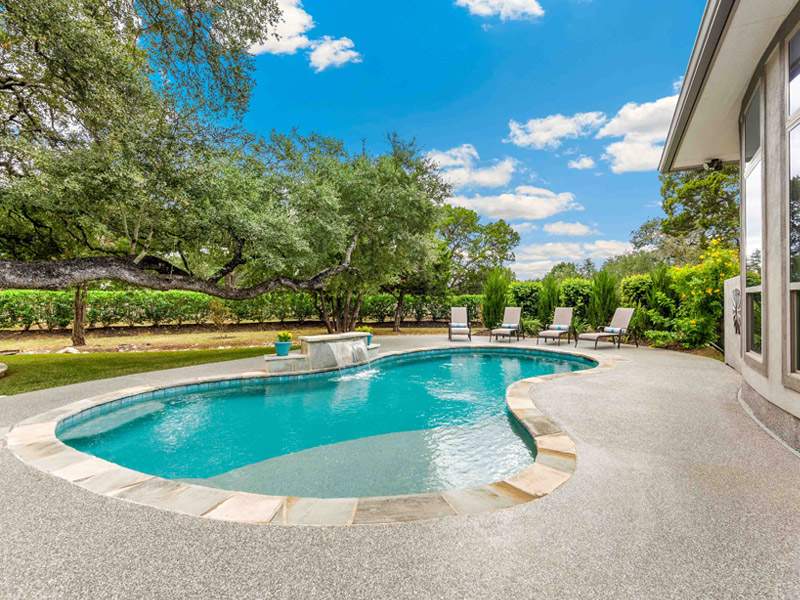 Durable concrete pool installed by Southern Screen LLC in Orlando, FL, with lounge chairs.