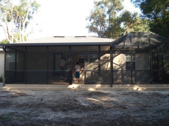 Spacious screened patio enclosure with a door at this home by Southern Construction Pools.