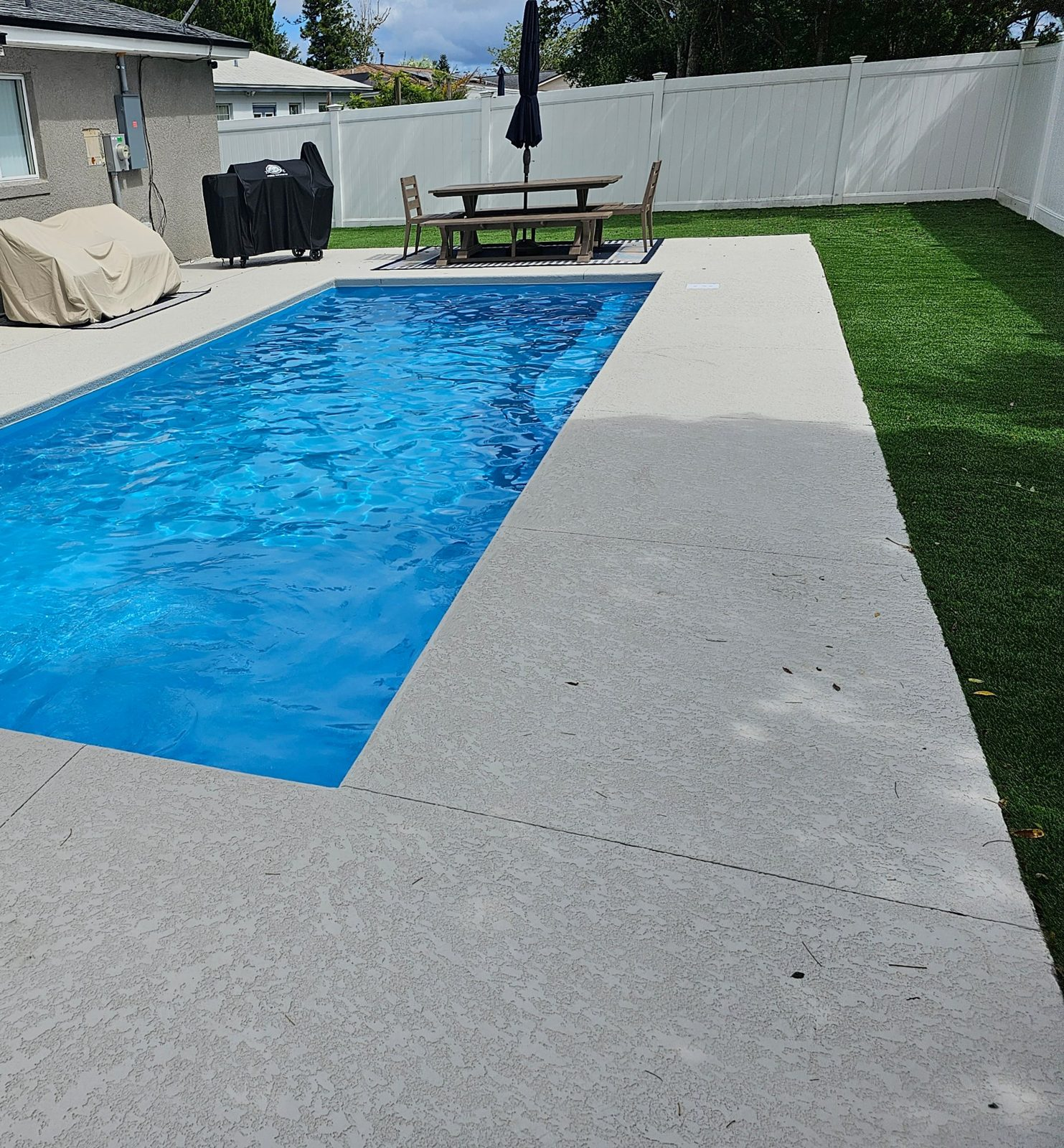 Rectangular San Juan Wylela Beach fiberglass pool with acrylic knockdown deck and artificial turf