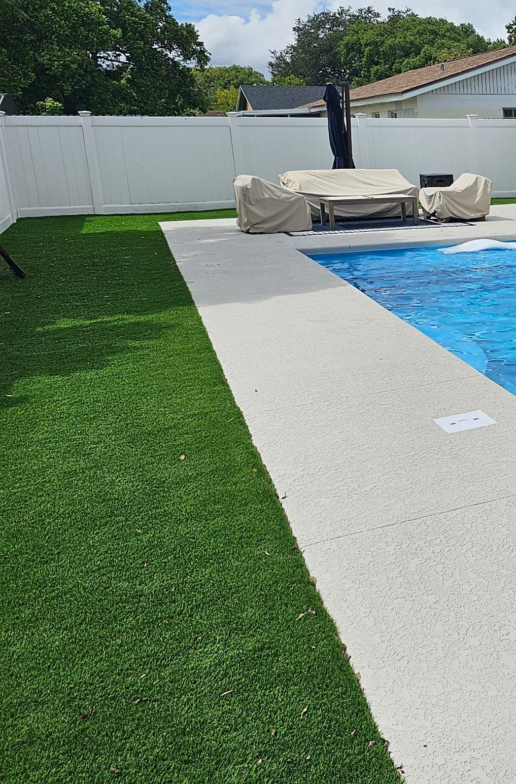 Acrylic knockdown concrete pool deck next to artificial turf in Casselberry