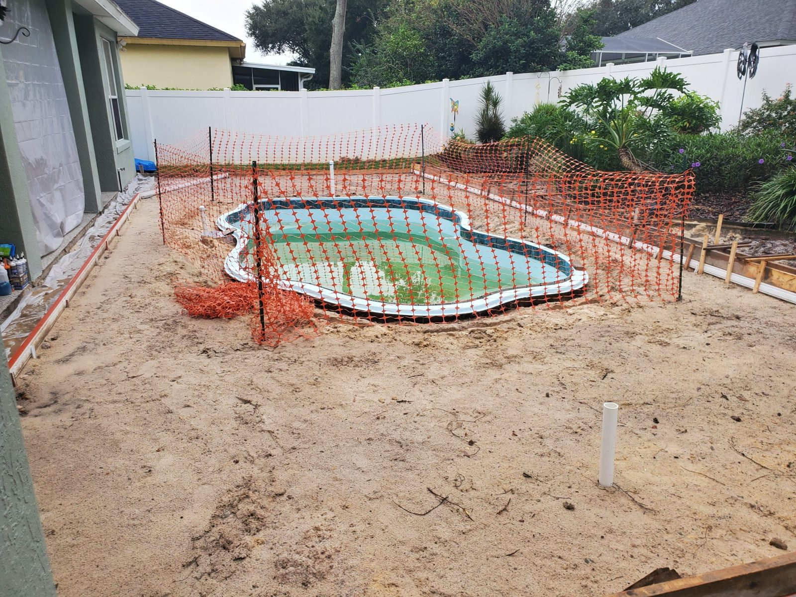 Fiberglass pool shell set and backfilled in a DeBary backyard