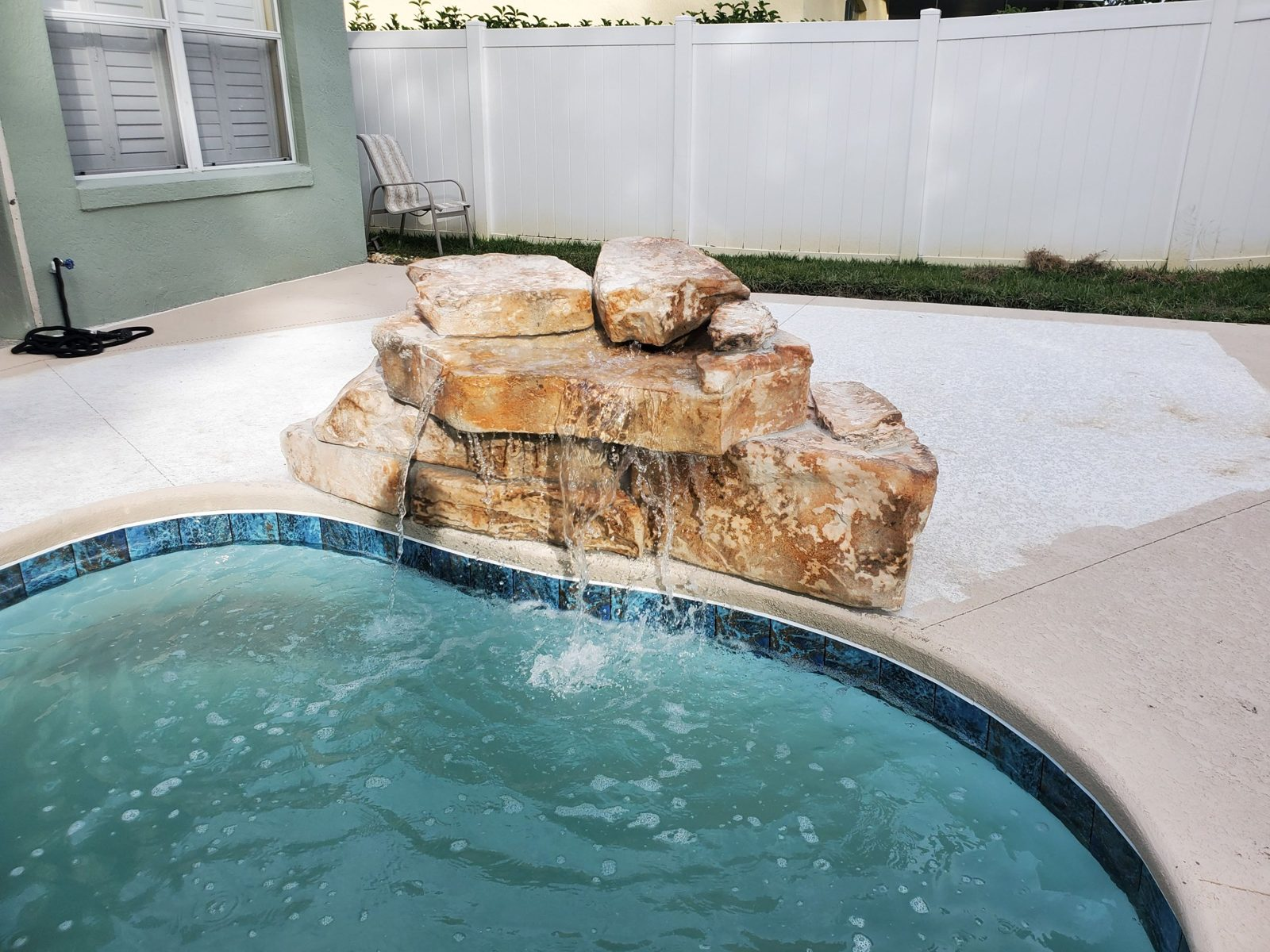 Rico Rock waterfall flowing into a fiberglass pool