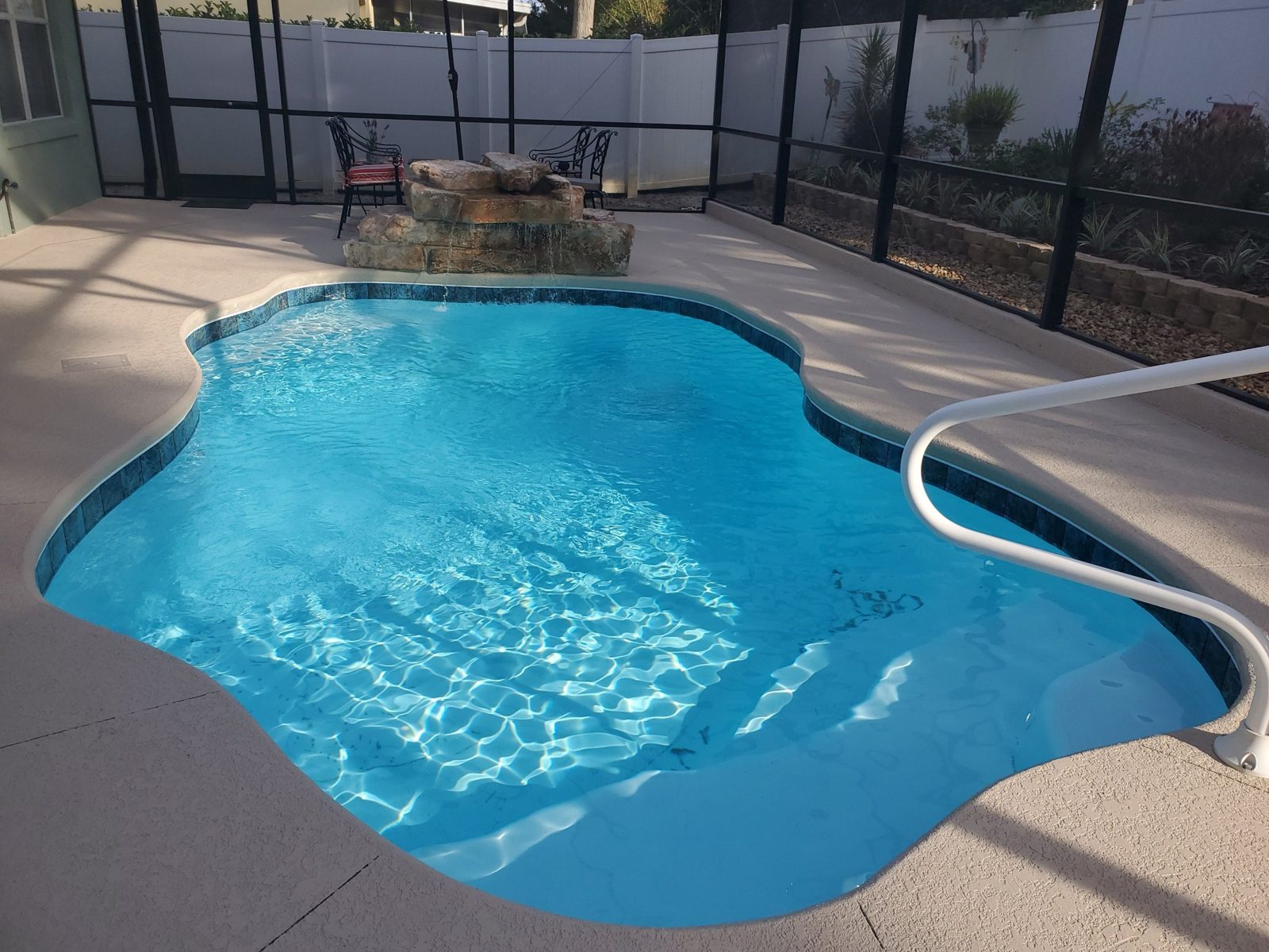 Close view of a San Juan Ariella fiberglass pool with entry steps and handrail