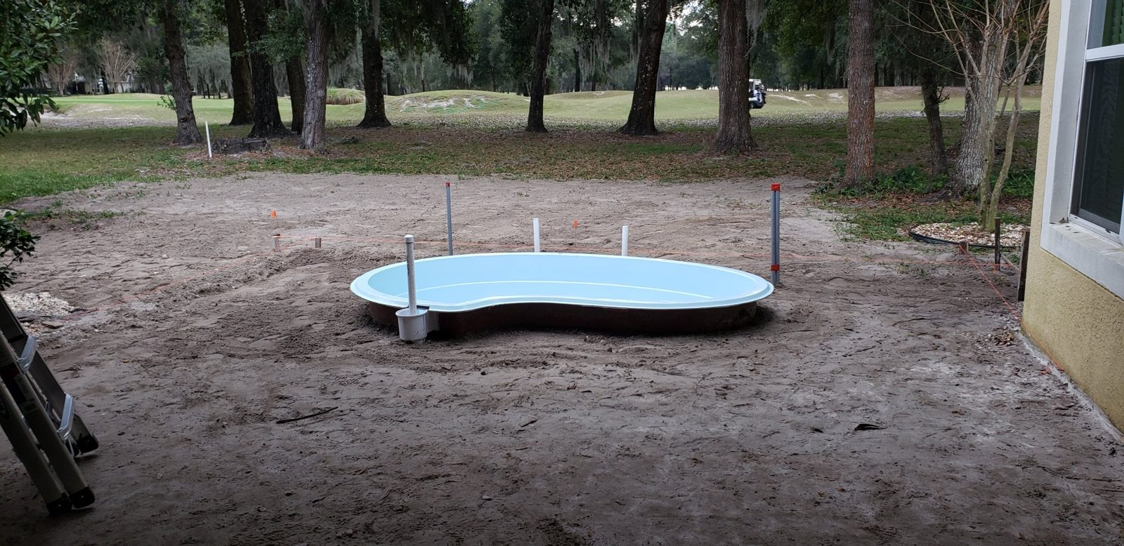Fiberglass spa shell set partially in-ground in a DeLand backyard