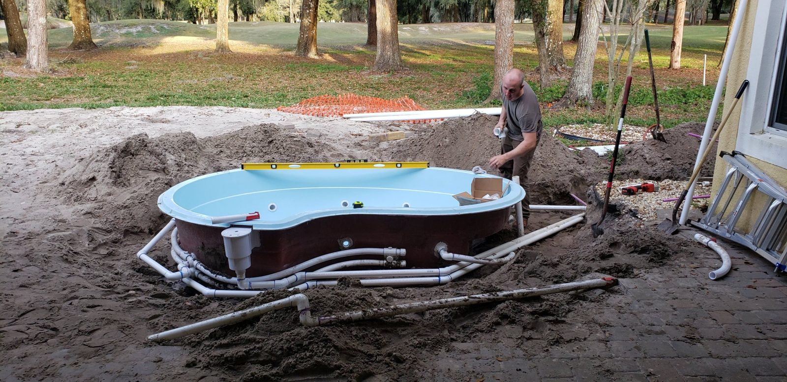 Spa plumbing lines run around a fiberglass shell