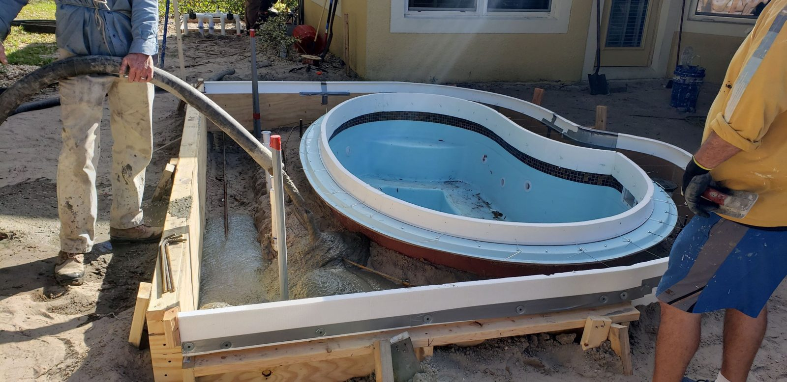 Concrete pumped into forms around a fiberglass spa