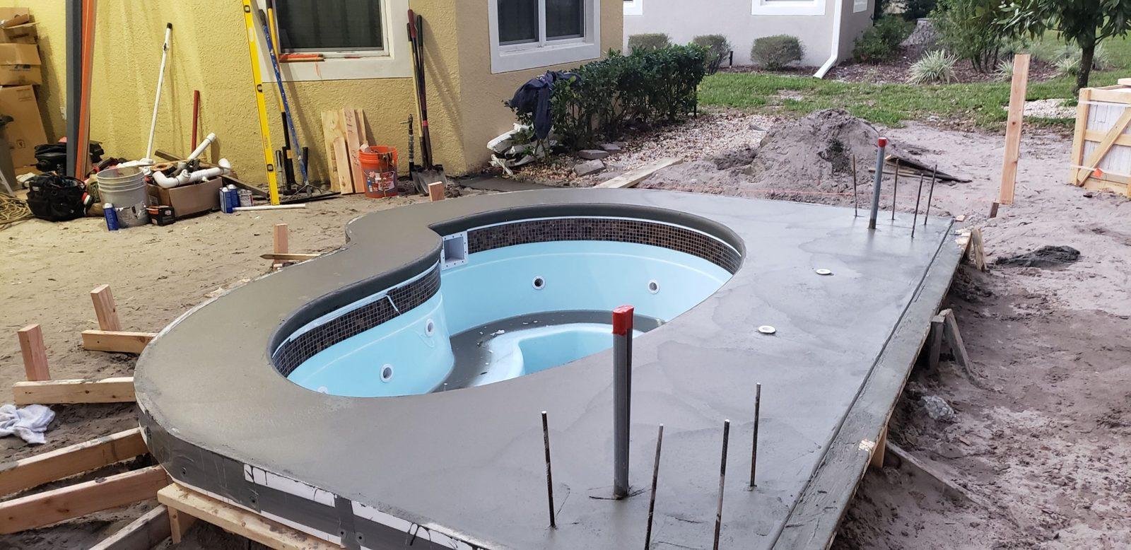 Freshly poured concrete cap around a fiberglass spa