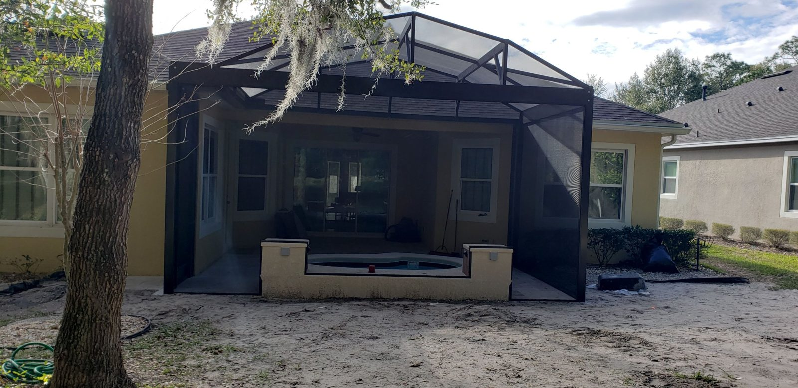 Screen enclosure with a raised spa behind a DeLand home