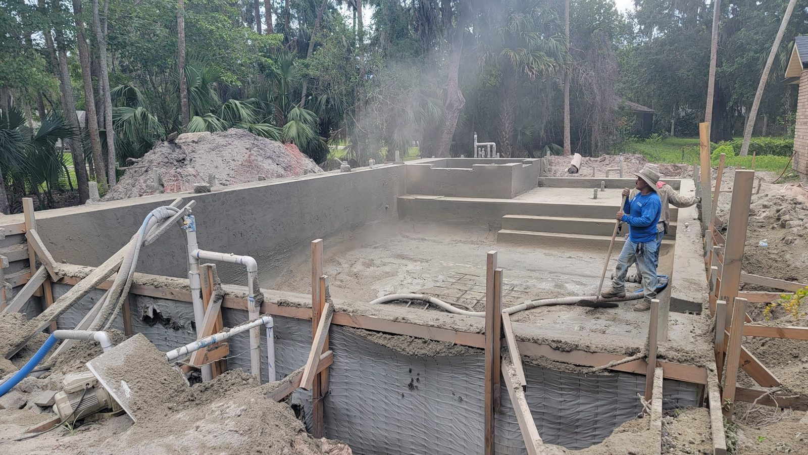 Freshly shot gunite pool shell with tanning ledge and raised spa