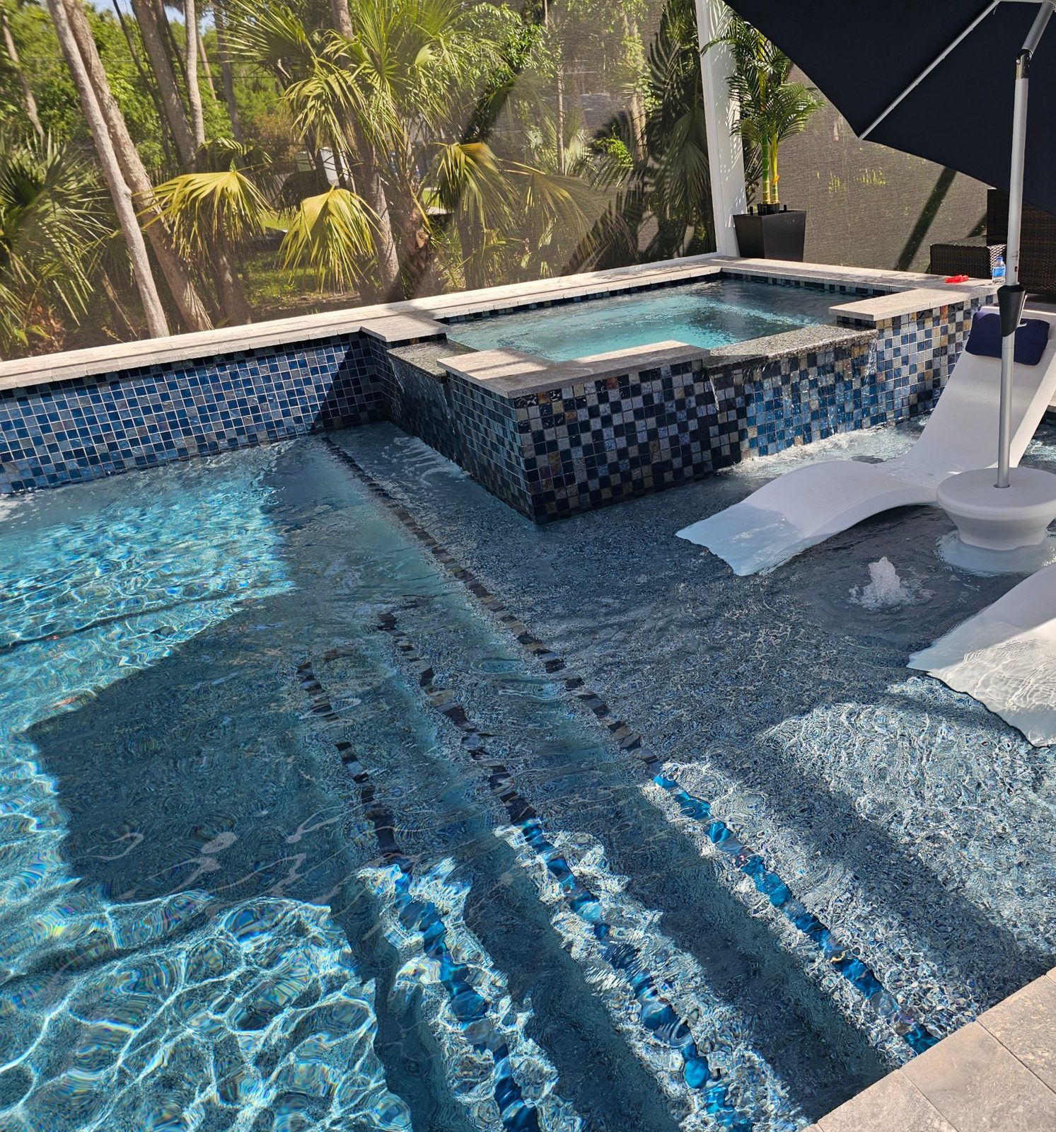 Tanning ledge with bubblers and spa spillovers on a glass bead finish pool