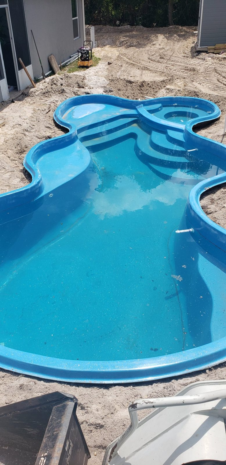 San Juan Desert Springs fiberglass pool shell with attached spa set in a Deltona backyard