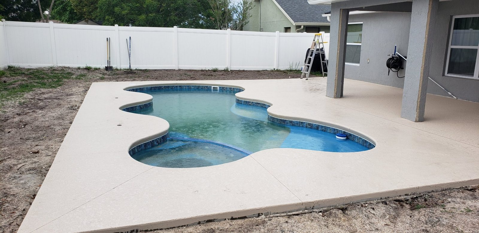 Acrylic knockdown concrete deck around a San Juan Desert Springs fiberglass pool