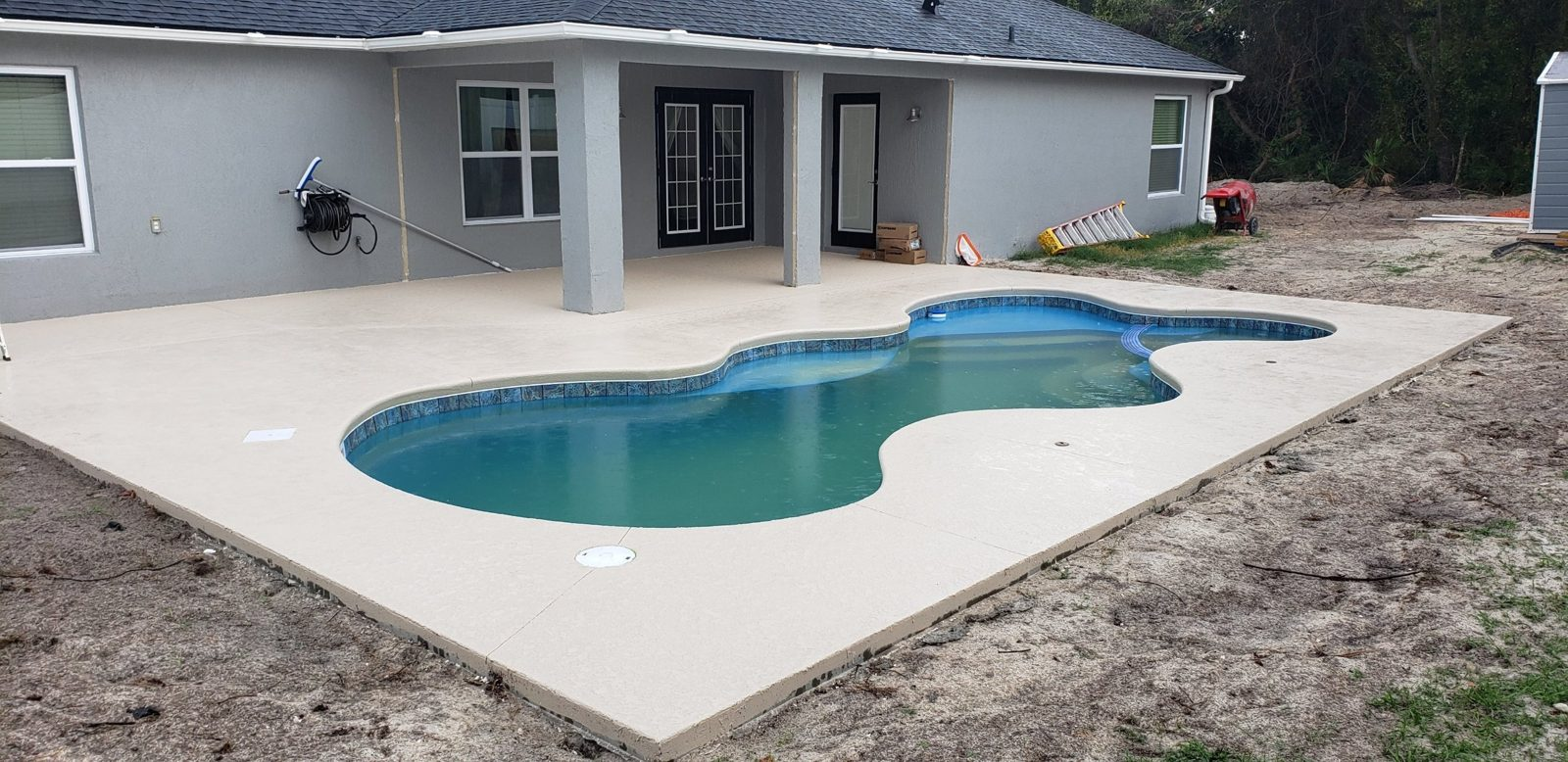 Concrete pool deck tied in to a covered lanai
